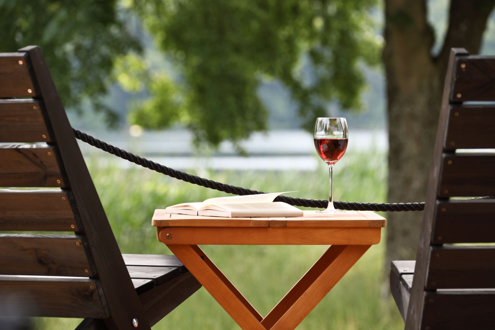 Liegestuhl und Weinglas am See